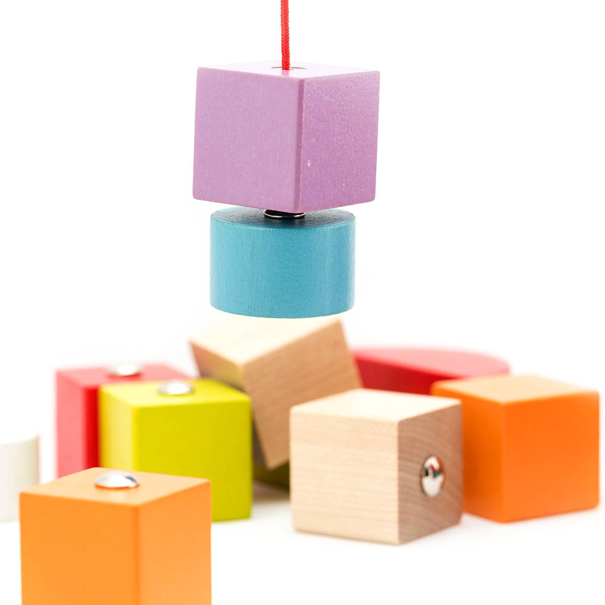 Colorful wooden blocks hanging from a string on a white background