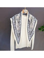 Muted grey triangle bandana scarf with vintage paisley print, draped on hanger