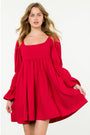 Woman wearing a red dress with long sleeves on a white background