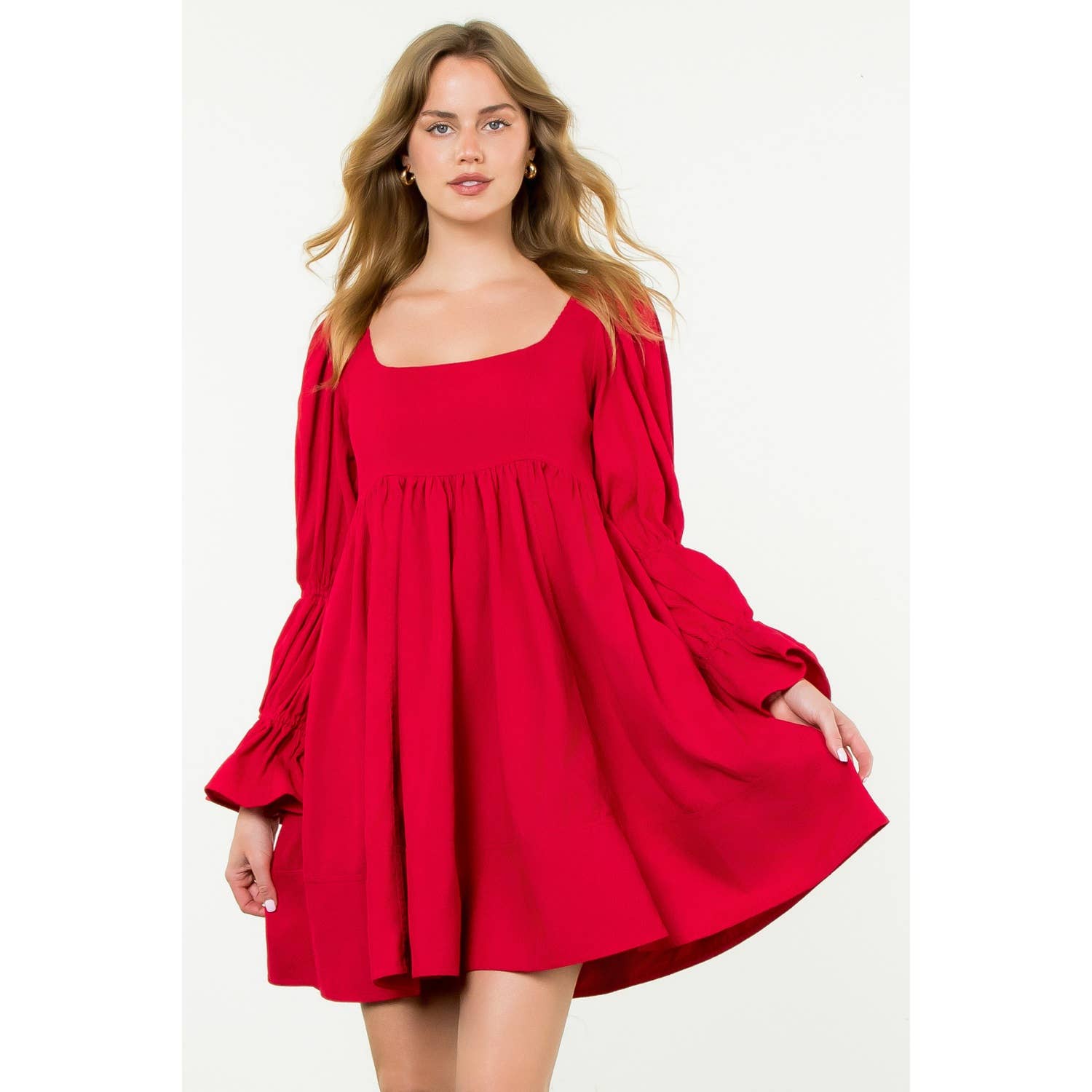 Woman wearing a red dress with long sleeves on a white background