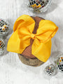 Yellow hair bow on a wooden block with disco balls around