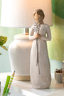 Decorative figurine on a desk with a lamp and stationery items