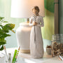 Decorative figurine on a desk with a lamp and stationery items