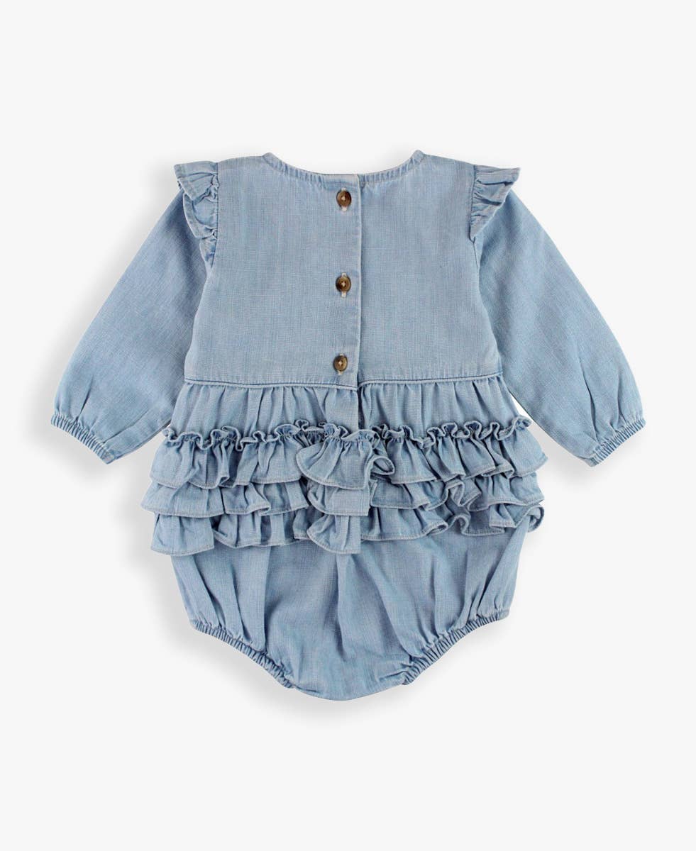 Light blue denim baby romper with ruffled details on a white background