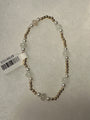 A beaded necklace with round white pearls and pale green stone beads separated by small metallic gold spacer beads, shown on a textured light gray background with a white product tag attached.