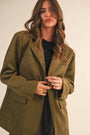 Woman wearing a green coat against a plain background