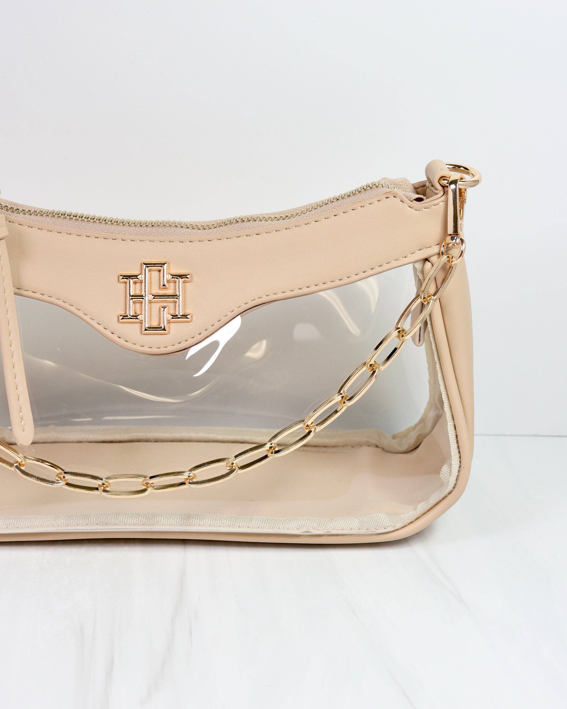Beige handbag with gold chain detail on a white background