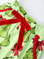 Green fabric with Grinch print and red bows on a white background