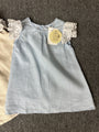 Light blue dress with lace sleeves on a textured surface