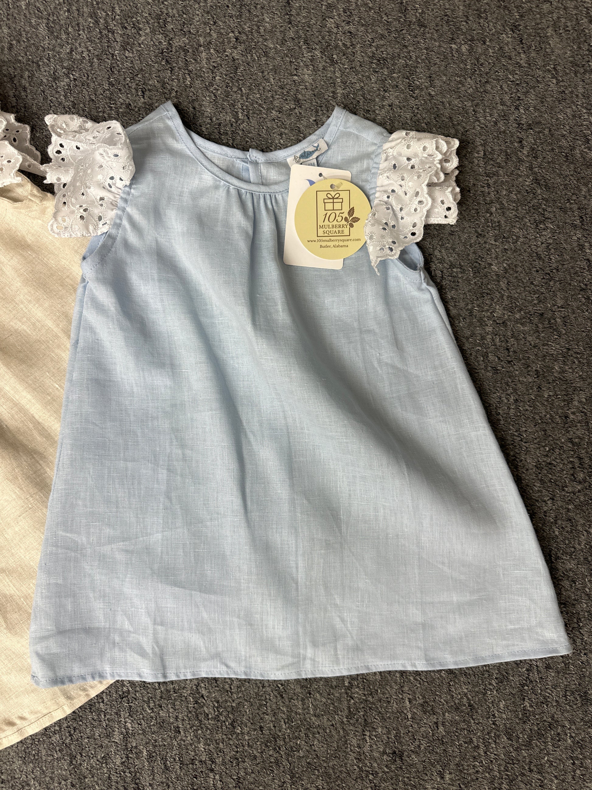 Light blue dress with lace sleeves on a textured surface