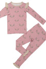 A two-piece children's pajama set in dusty pink, featuring an all-over green leaf pattern and beige ruffle trim on the collar and cuffs, laid flat on a white background.
