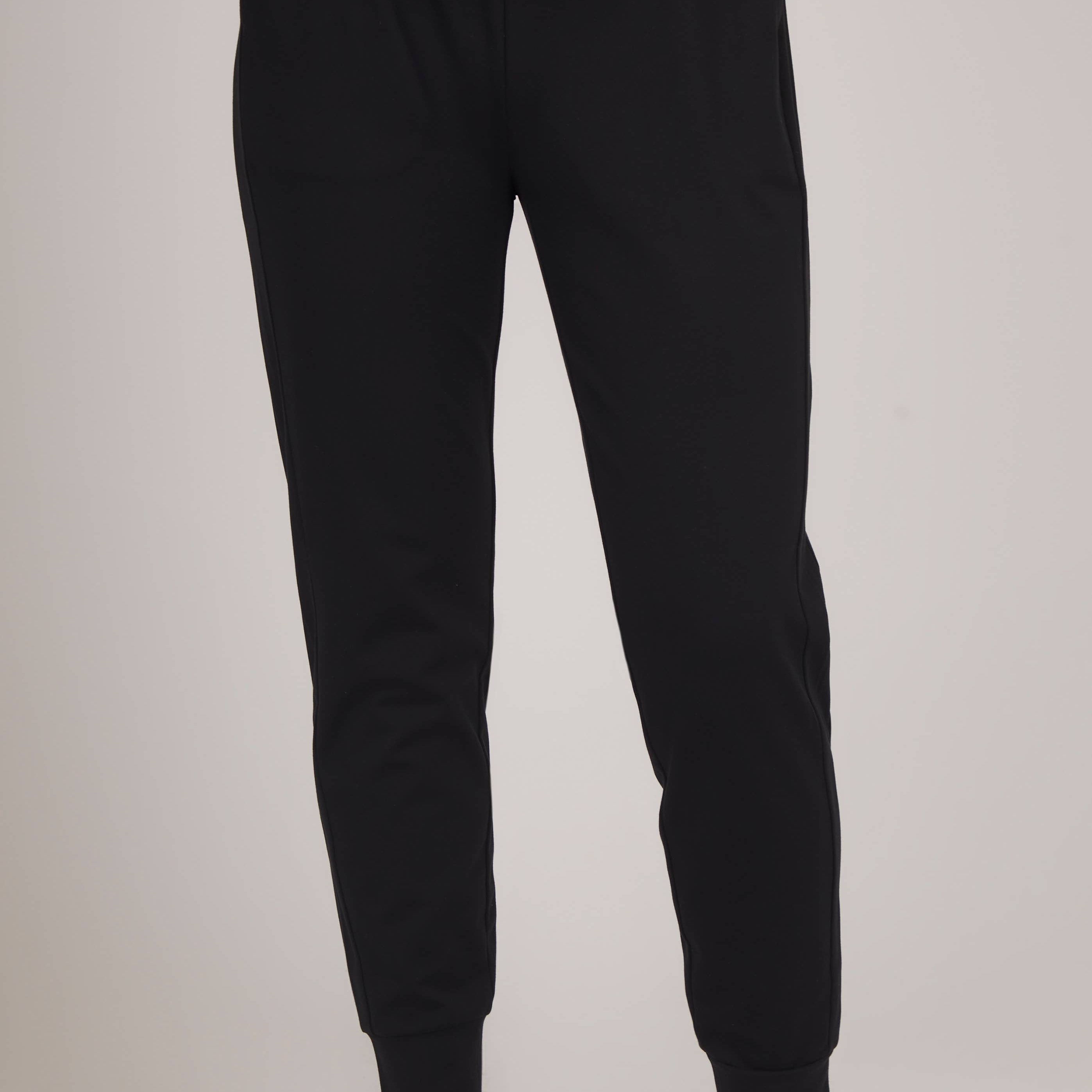 Black jogger pants worn by a person on a plain background