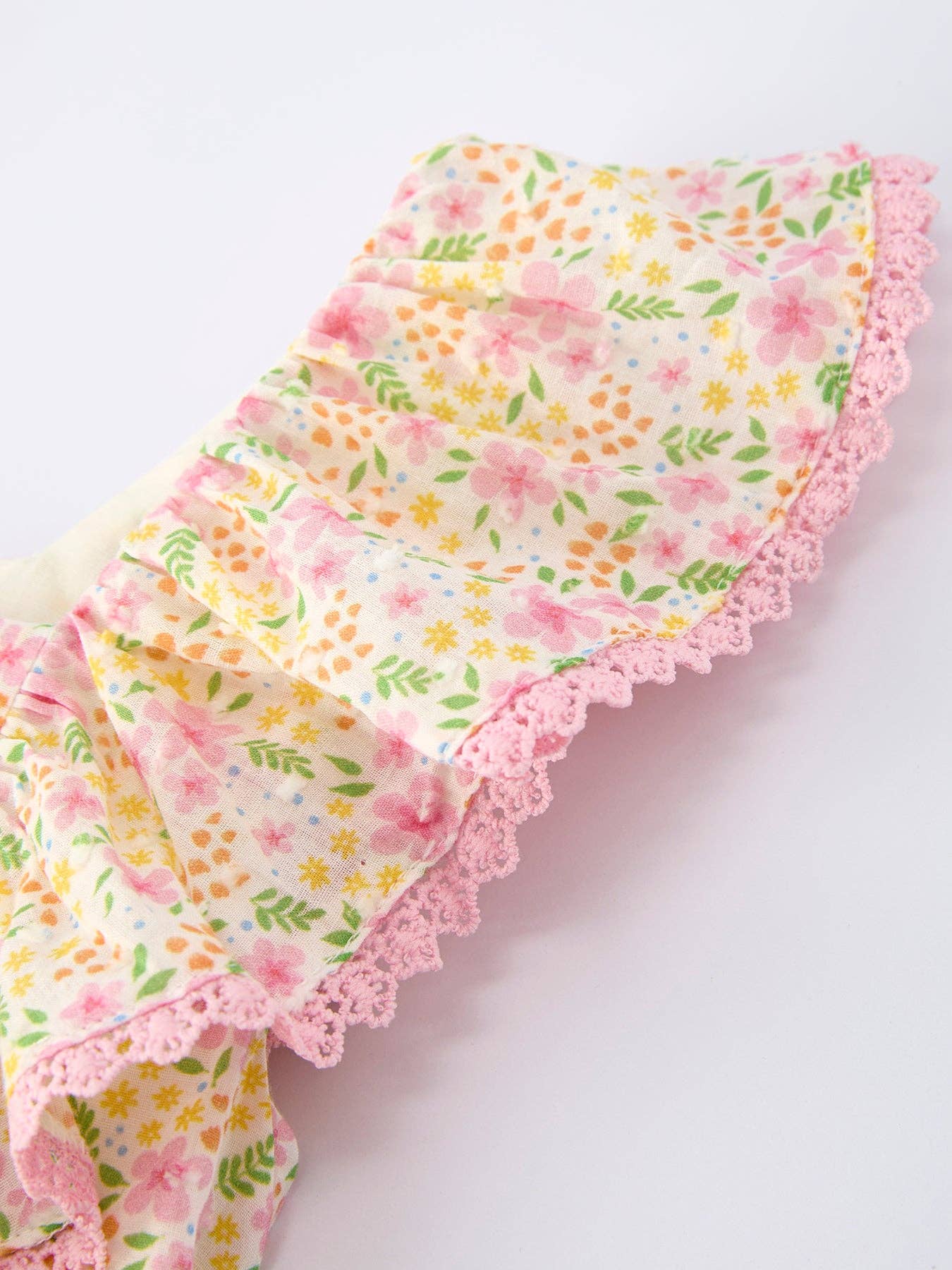 Floral fabric with pink lace trim on a light background