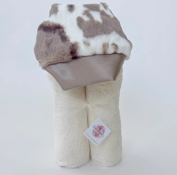 Plush toy with cow print top and beige bottom on a white background