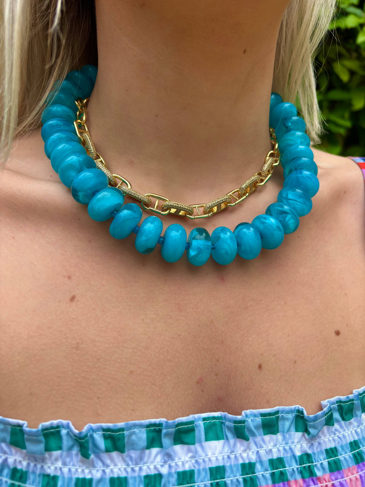 Chunky beaded necklace with teal oval beads and gold link clasp