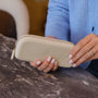 person holding a cream colored silicone eyeglass case with Peepers logo