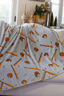 Blanket with baseball-themed pattern draped over a couch in a living room.