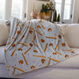 Blanket with baseball-themed pattern draped over a couch in a living room.