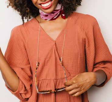 Woman wearing a rust-colored dress with a white background