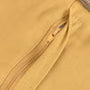 A close-up of a mustard yellow fabric surface with a matching zipper running diagonally across the frame.