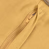 A close-up of a mustard yellow fabric surface with a matching zipper running diagonally across the frame.