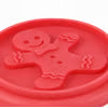 A close-up of a bright red silicone mold or stamp featuring a gingerbread man design, with a textured surface and a small circular hole near the top.