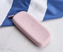 Lilac silicone eyeglass case with Peepers logo on a white and blue striped background