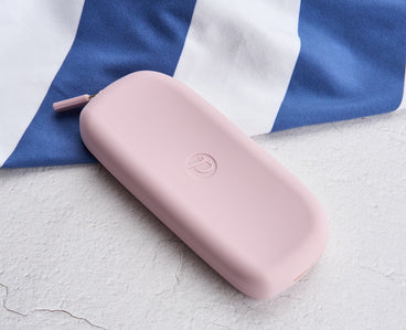 Lilac silicone eyeglass case with Peepers logo on a white and blue striped background