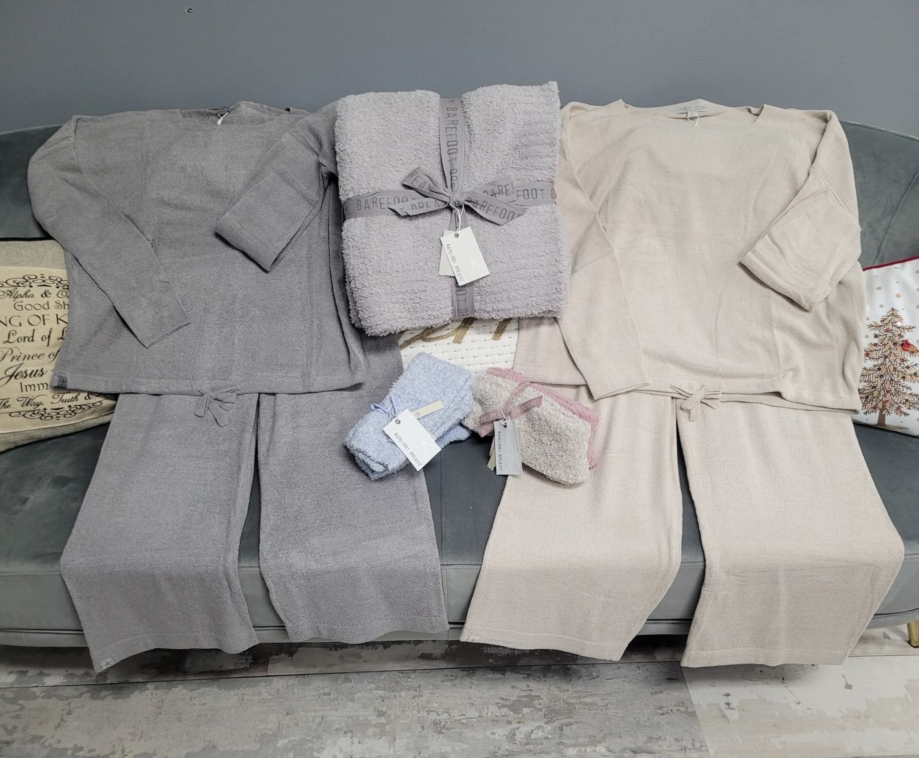 Gray and beige bath towels on a gray sofa with price tags.