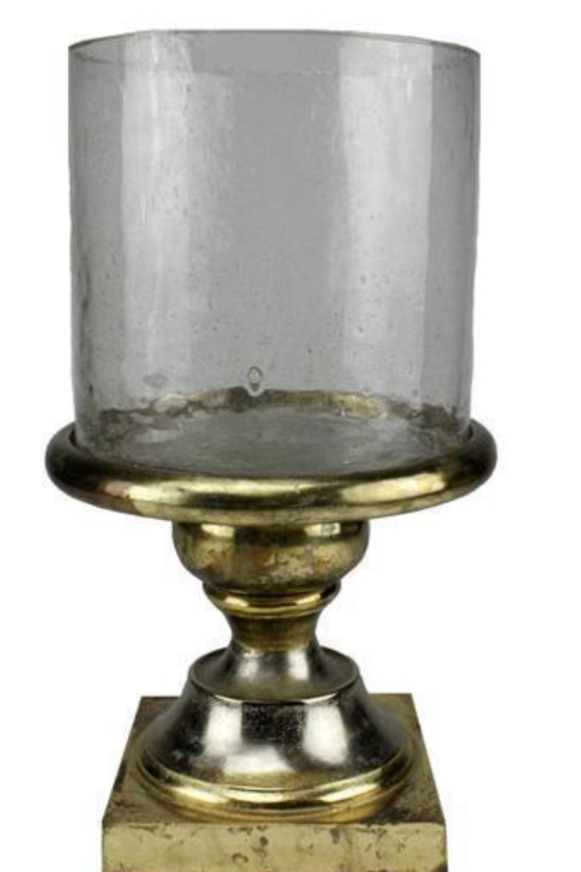 Decorative candle holder with clear glass and gold base on a white background