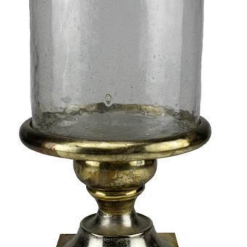 Decorative candle holder with clear glass and gold base on a white background