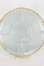 Clear glass plate with gold decorative rim on a white background