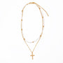 Gold necklace with a cross pendant on a white background