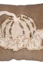 Decorative pillow with embroidered pumpkin and leaves on a brown background