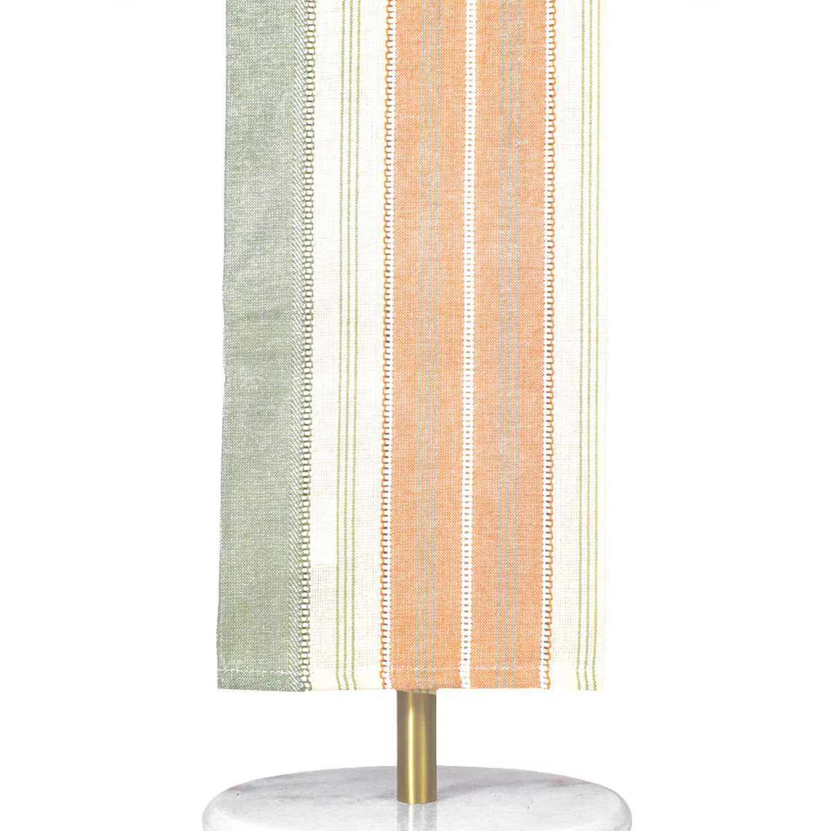 Striped towel hanging on a gold towel rack with a white base