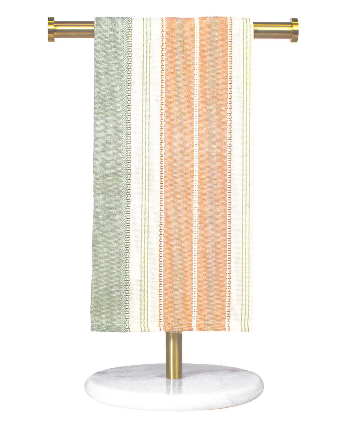 Striped towel hanging on a gold towel rack with a white base