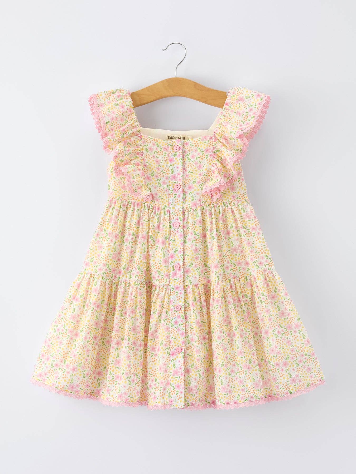 Floral dress on a hanger against a white background
