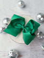 Green bow on a white surface with silver decorative elements