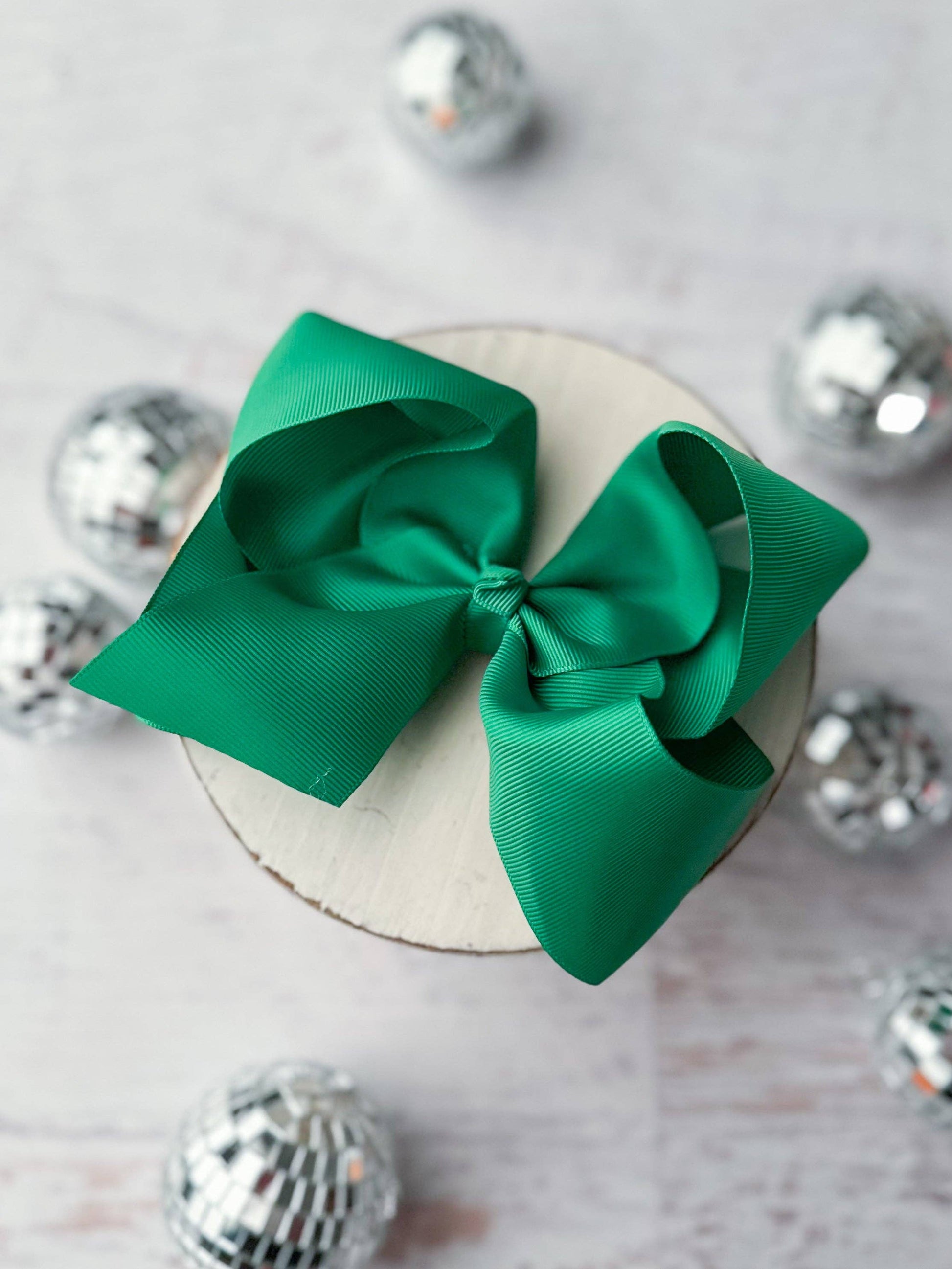 Green bow on a white surface with silver decorative elements