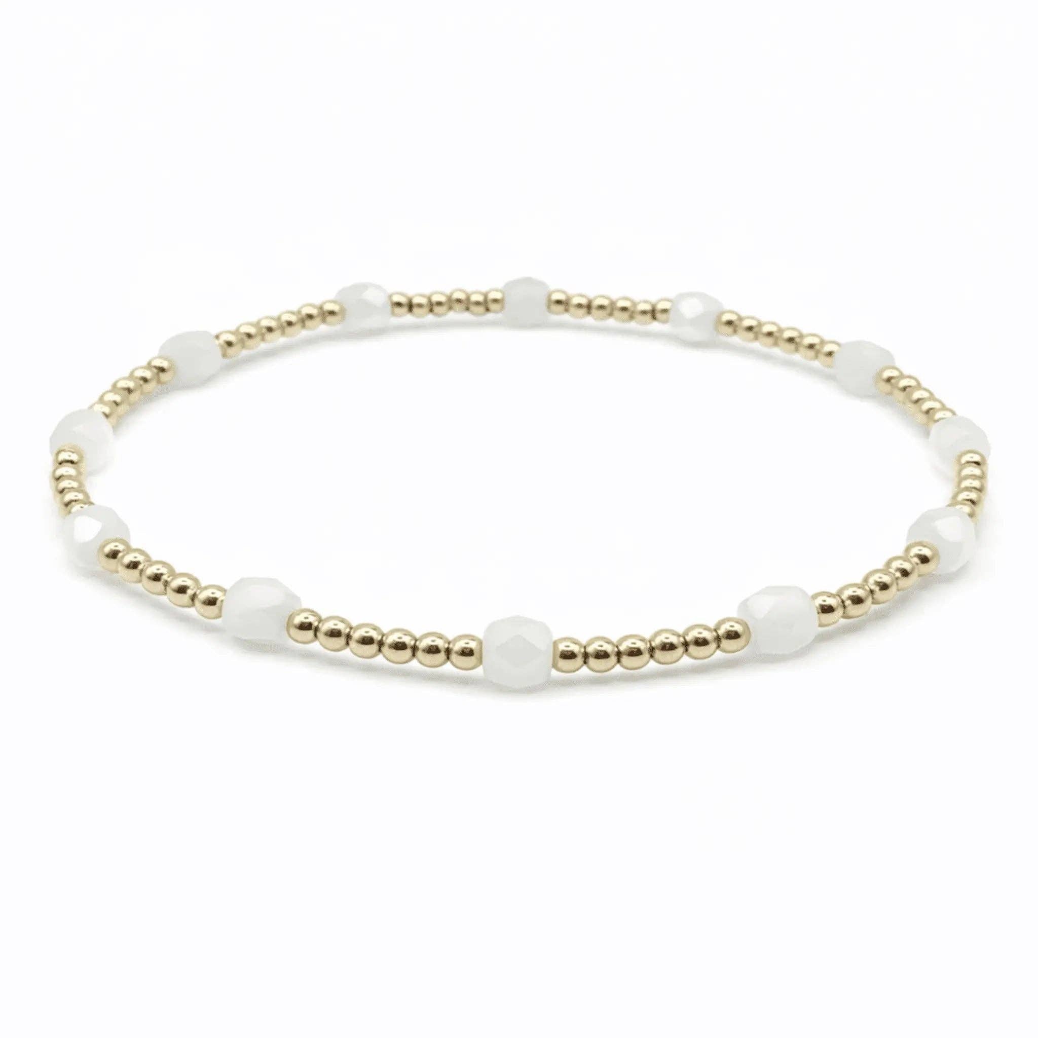 Bracelet with white beads and gold accents on a white background