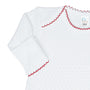 White baby gown with red trim on a white background