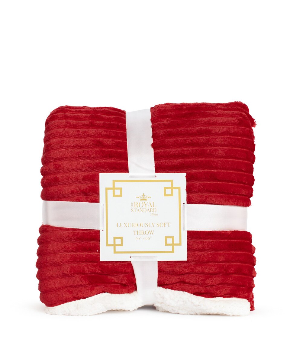 Red textured throw blanket with a white label on a white background