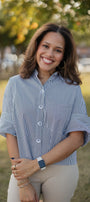 Woman wearing a black and white striped shirt outdoors with blurred background