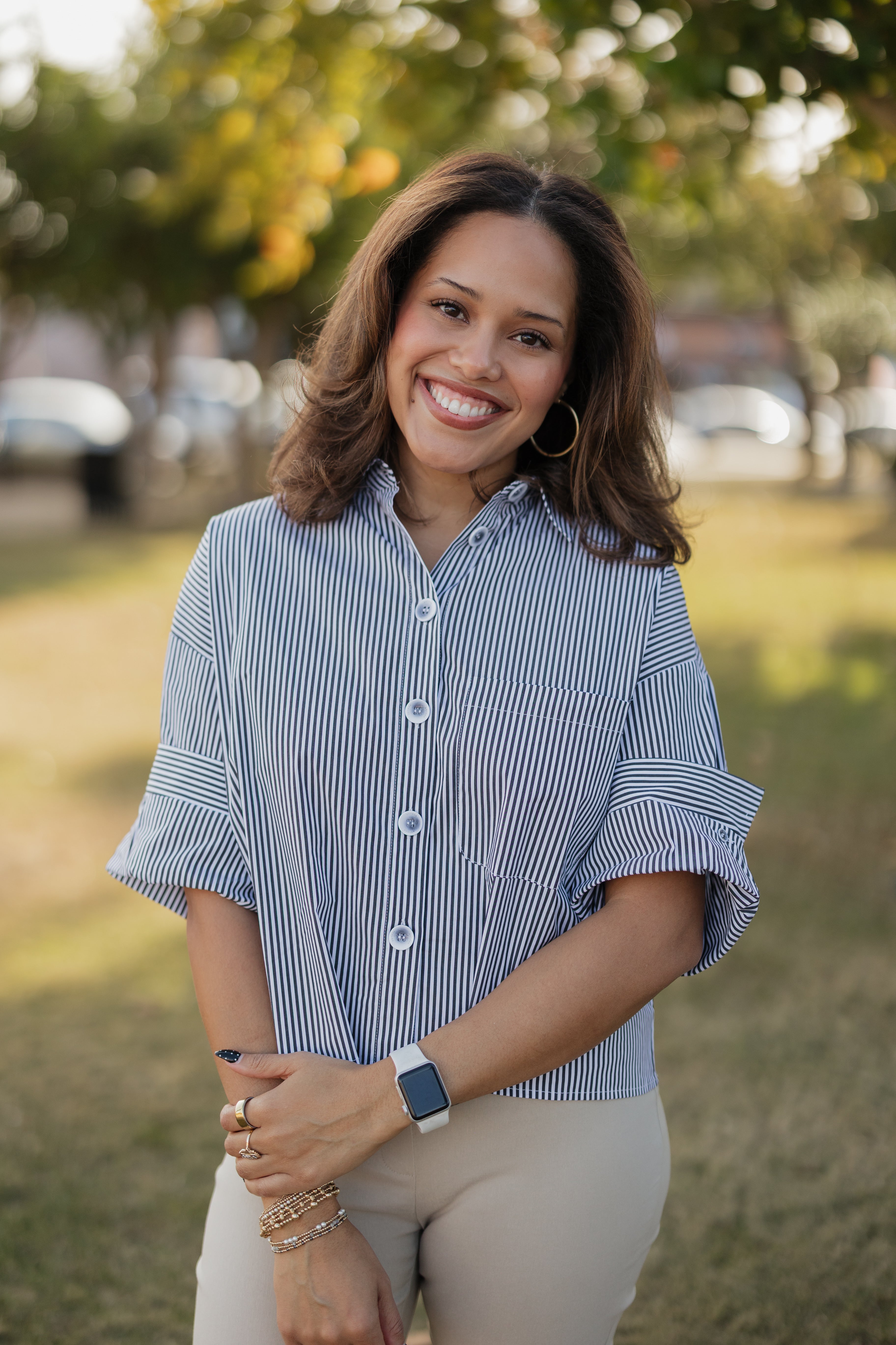 Woman wearing a black and white striped shirt outdoors with blurred background