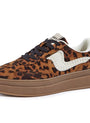 A platform sneaker featuring a brown and black leopard print upper, a thick brown gum sole, a white braided side accent, and a white heel tab.