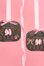 Two dark green fabric pouches tied with pink bows