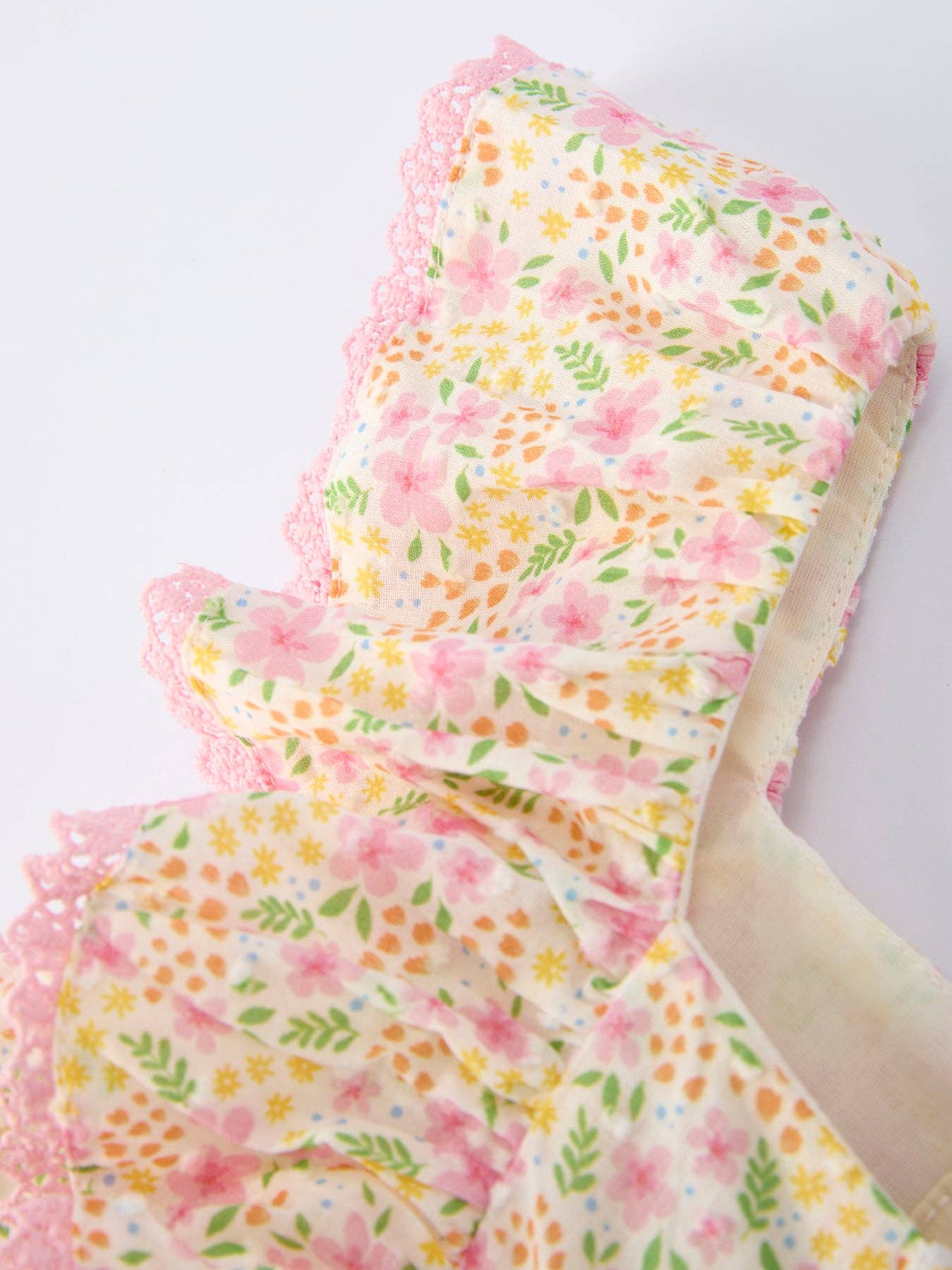 Floral-patterned fabric with ruffled edges on a white background