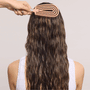 Video of someone brushing brunette hair with a flexi brush