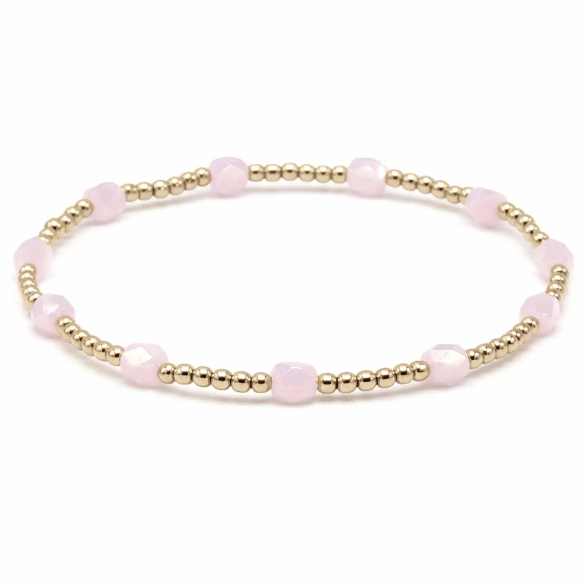Bracelet with pink beads and gold accents on a white background