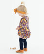 Child wearing a floral dress with a white background